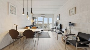 Un intérieur moderne comprenant un coin repas, des sièges et un téléviseur.