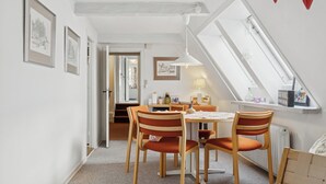 En matplats med ett bord, stolar och en taklampa.