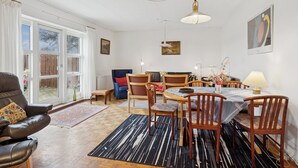 A spacious room with a dining area, a sofa, and a chair. - Holiday home on large grounds with beautiful view (Humble)