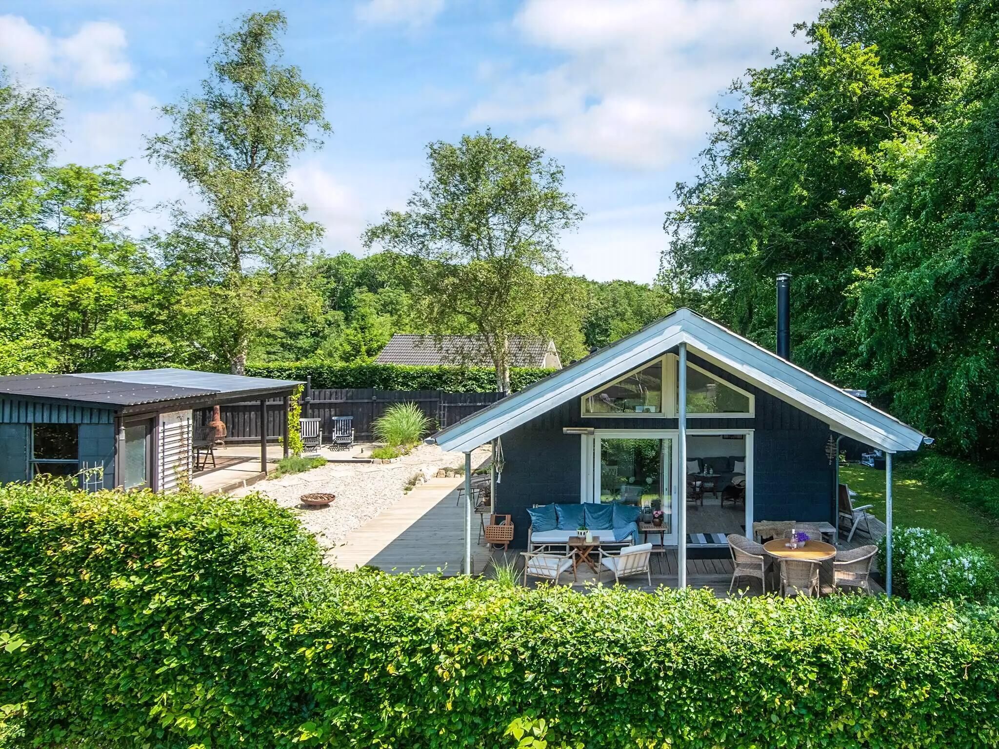 A house with a patio, outdoor seating, and a garden.