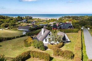 A coastal residential area with houses, a flag, and a view of the sea. - Idyllic summer house with sea view (Glesborg)