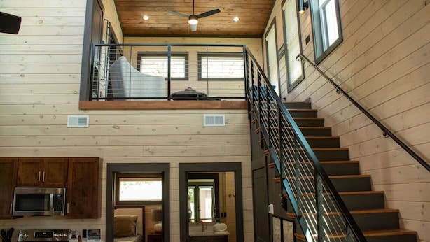 Ein geräumiges Loft mit hohen Decken, einer Wendeltreppe und einem großen Fenster.