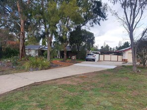 A residential driveway with a car parked in front of a house.