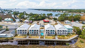 A coastal hotel with multiple-story buildings, a swimming pool, and a view of the sea. - Bayou Sunrise 3102 (Gulf Shores)