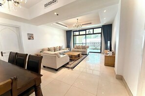 A modern living room with a dining area, a sofa set, a coffee table, and a chandelier. - Burj Khalifa View Luxury 2BR Apartment Souk Al Bahar Downtown Dubai (Dubai)