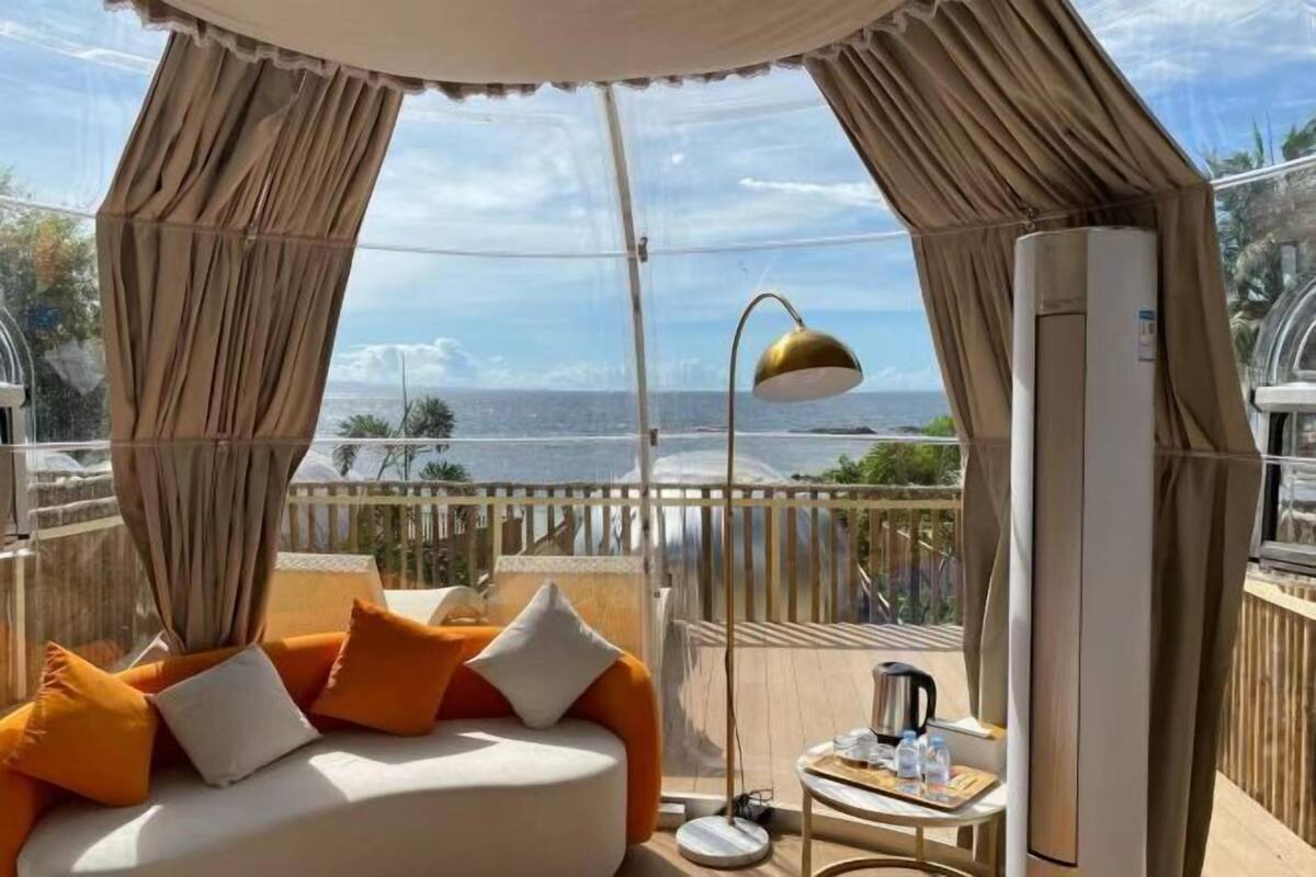 Ein Balkon mit einem Bett, einem Tisch mit Wasserkocher und einer Klimaanlage.