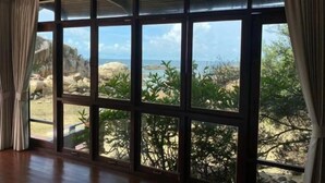 Une pièce dotée de grandes fenêtres donnant sur un paysage rocheux et une végétation luxuriante.
