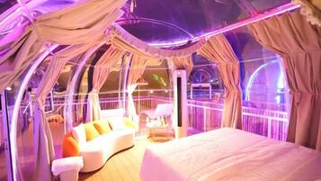 A tent-like room with a bed, a sofa, and a small table.