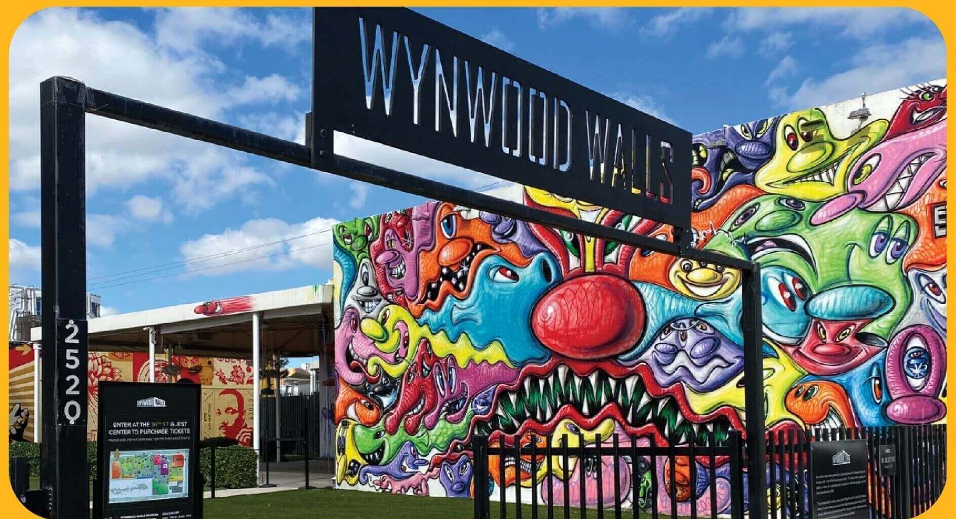 Wynwood Walls con un mural colorido y un cartel que indica el centro de visitantes 2529 para la compra de entradas.