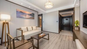 Una hall d'albergo moderna con un divano, un tavolino da caffè e un quadro appeso al muro.