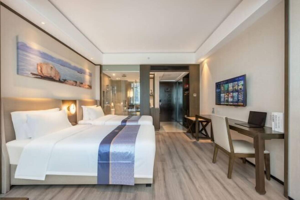 Ett hotellrum med en stor säng, ett skrivbord och en tv.