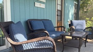 A covered porch with wicker furniture, including two rocking chairs and a table. - Beautiful and modern single home located 5 minutes from Indian Rocks Beach . (Largo)