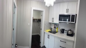 A compact kitchen with white cabinets, a microwave, a kettle, and a toaster. - Private Master Bedroom on second floor (Mississauga)