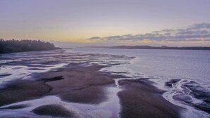 A beach with wet sand and a calm sea. - The Cottage at Seagate | Cozy Coos Bay Retreat (Coos Bay)
