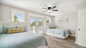 A bedroom with two beds, a ceiling fan, and a view of the outdoors. - Private Pool/Walk to the Beach/Sleeps10 (Panama City Beach)