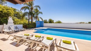 Ein Poolbereich mit Liegestühlen und einem klaren, blauen Pool.