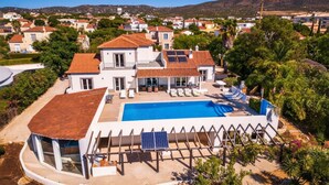 Ein großes Haus mit Pool, überdachter Terrasse und Blick auf die Umgebung.