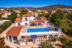 A large house with a swimming pool, a covered patio, and a view of the surrounding neighborhood. - Your private retreat with garden, terraces, and stunning sunset views. (Estoi)