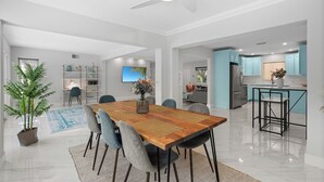 A spacious living area with a wooden dining table, grey chairs, and a ceiling fan. - Beautiful 2 bedroom bungalow in a quiet neighborhood (Fort Myers)