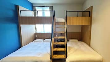 Quarto com beliche, parede azul, janela com cortinas e escada de madeira.