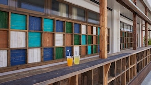 A wooden bench with a view of colorful wooden panels and a glass partition.