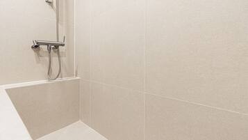 Une salle de bain avec une douche, des toilettes et un lavabo.