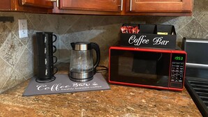 Eine Küche mit Kaffeemaschine, Schild mit Kaffee-Bar und Mikrowelle.