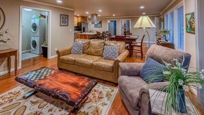 A living room with a sofa, a coffee table, and a dining area. - The Guest House & Cottage at Seagate- Coos Bay, OR (Coos Bay)