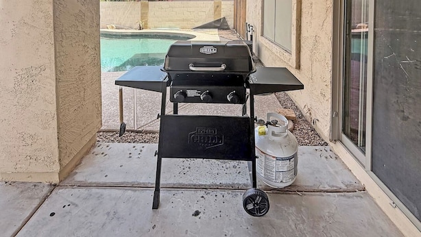 A barbecue grill with a gas tank and a propane bottle on a patio. - 3BR Casa Grande Home with Private Pool and Sofa Sleeper (Casa Grande)