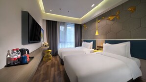 A hotel room with two beds, a flat-screen TV, a tray with water bottles and a mug, and a decorative wall with geometric patterns. - Jinglai Hotel · Curated Shanghai Xujiahui Jiaotong University Branch (Shanghai)