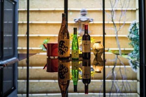 A room with a traditional Japanese sliding door, a red container, and a decorative vase. - KONJAKUSO Osaka Tsuruhashi "KAKUJU" (Osaka)