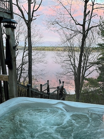Outdoor spa tub. Charming Lakefront Cottage