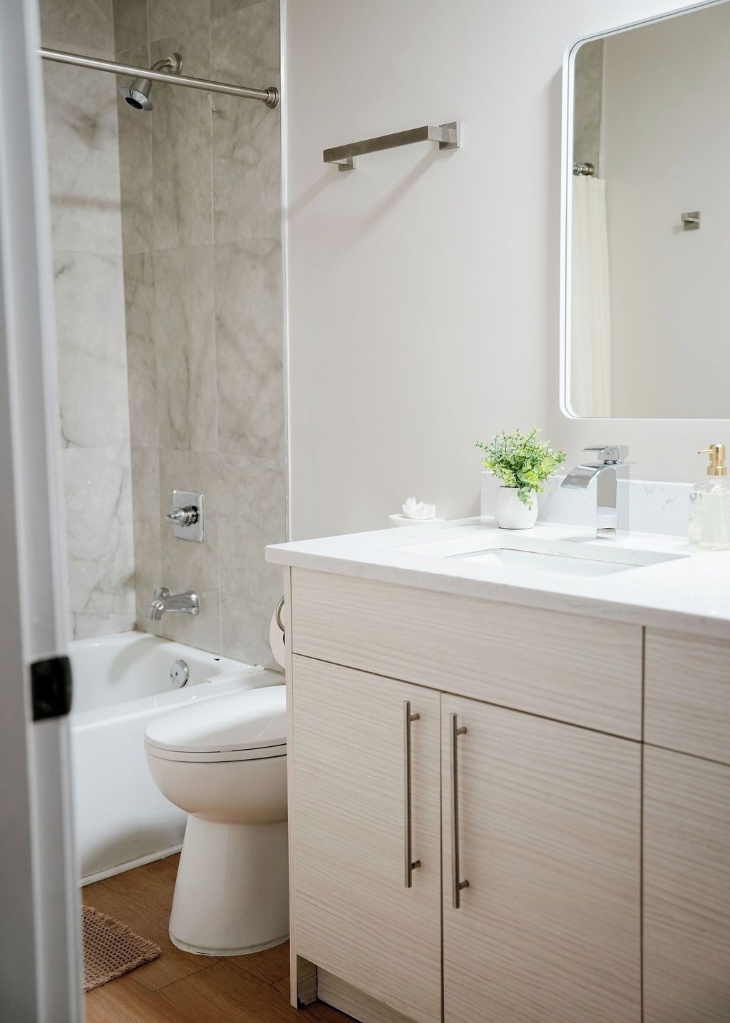 Un bagno moderno con vasca, servizi igienici e mobile lavabo.