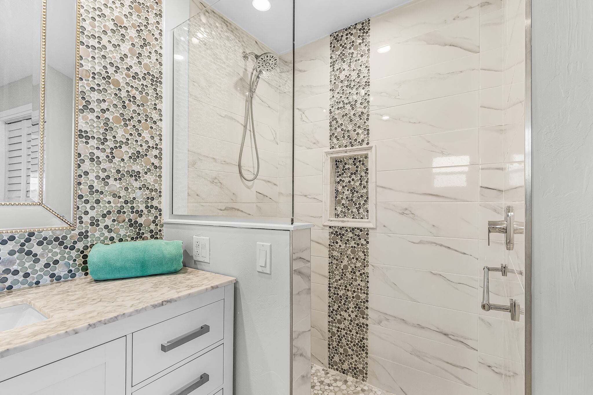 A bathroom with a shower, a sink, and a mirror.