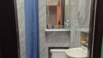 Een douche, handdoeken, zeep, toiletpapier