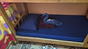 A bunk bed with a blue mattress and a brown pillow.