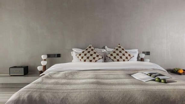 A modern bedroom with a bed, pillows, bedside table, and a small fruit basket. - Mandi Lake View Inn (Dali)