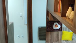 Eine moderne Küche mit Holzausstattung, einer integrierten Bücherreih und einem leuchtend gelben Hocker.