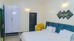 Une chambre d’hôtel comprenant un lit, une armoire, une porte et une œuvre d’art accrochée au mur.