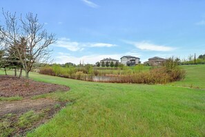 Un quartier résidentiel avec des maisons, un étang et un champ d’herbe.