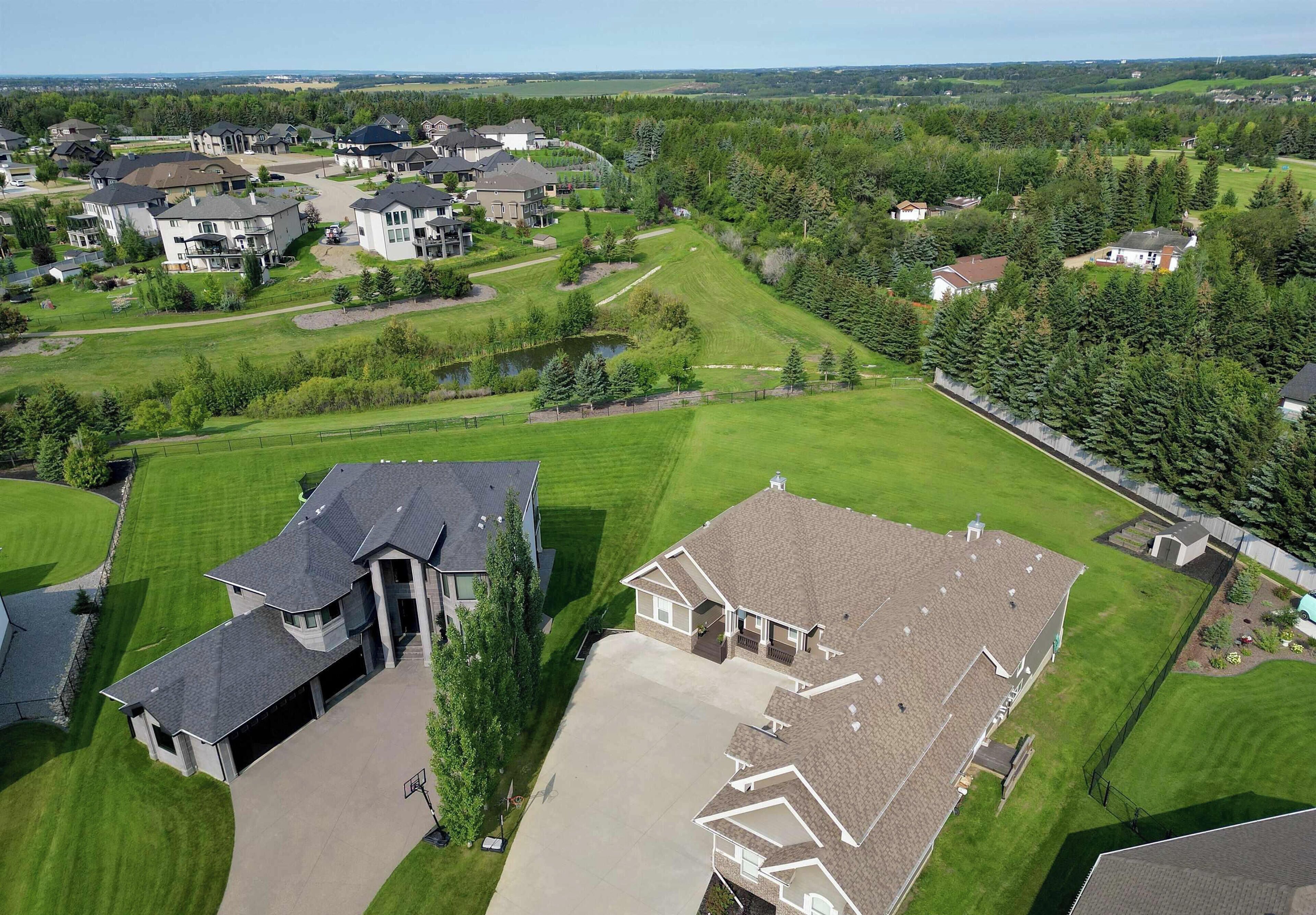 A residential area with houses, green lawns, and a clear sky.