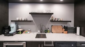 Una cocina moderna con lavavajillas integrado, cafetera y bloque de cuchillos.
