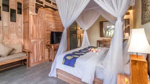 Ein Schlafzimmer mit einem Himmelbett, einem Holzschrank und einem Fernseher.