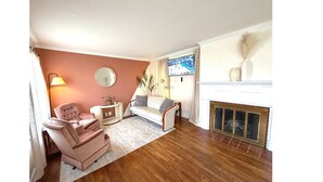 Ein Wohnzimmer mit Kamin, Fernseher und einem runden Spiegel an der Wand.