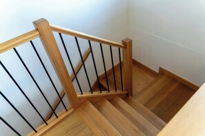 A wooden staircase with black balusters and a wooden handrail. - Spring Deals | Lux 4BR w/ Modern Kicthen & A/C (Vermont South)