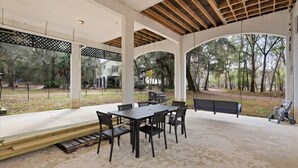 Un patio exterior con una mesa y sillas, un banco y una parrilla.