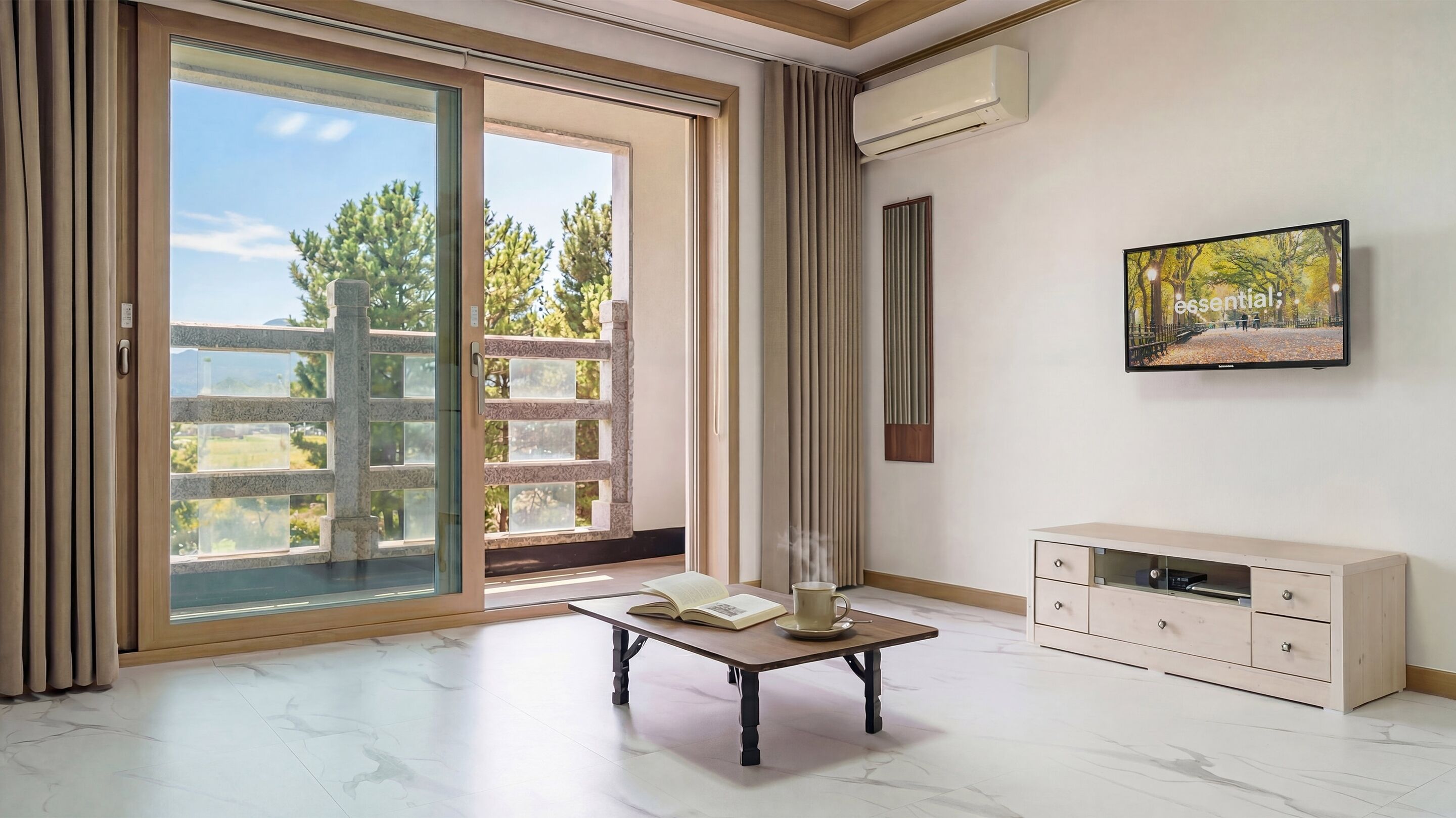Una habitación moderna con una puerta corrediza de vidrio, una mesa con un libro y una taza, un televisor y un cuadro en la pared.