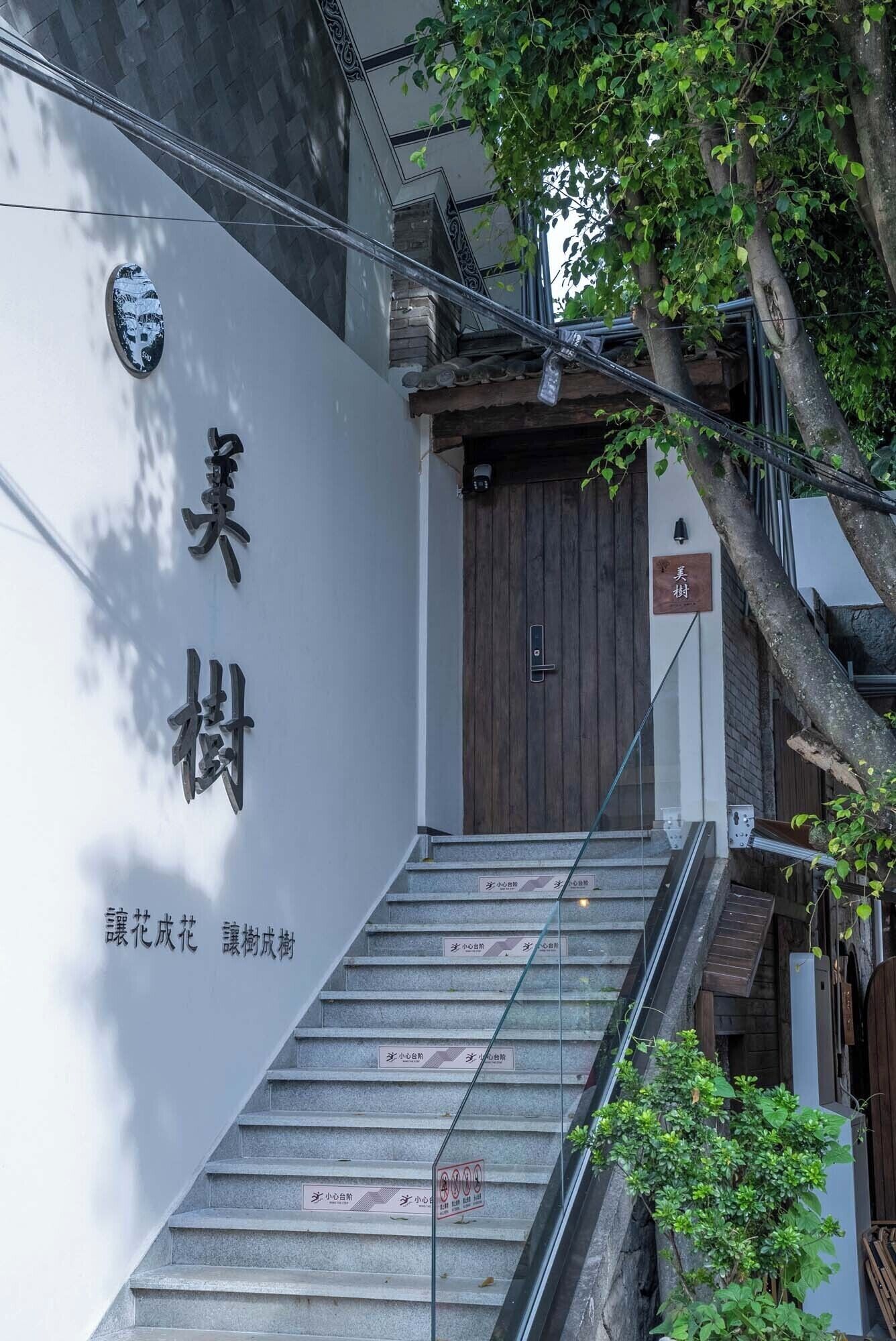 A staircase leading to a wooden door with a sign above it.