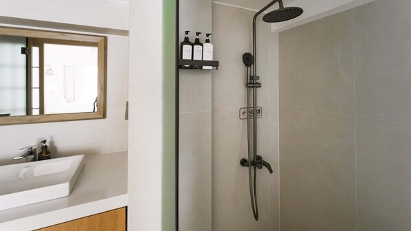 Un baño moderno con ducha, lavabo y espejo.