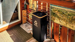 A wooden deck with a flag, a recycling bin, and a map of West Kootenay & Boundary Country.